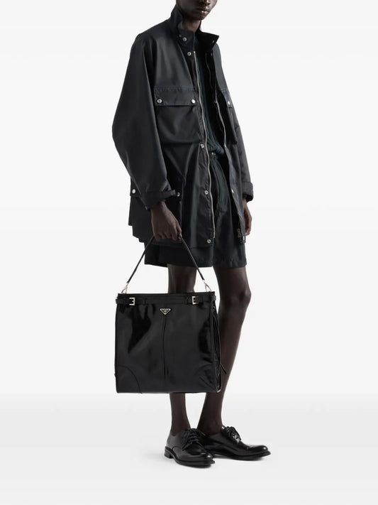 Prada Bonnie Leather Shoulder Bag in Black, carried by hand, worn view — The Quiet Edition