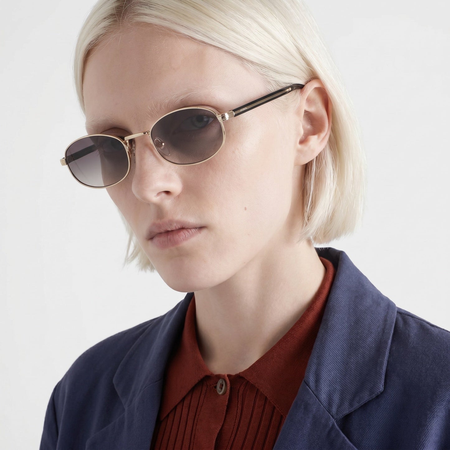 Prada PR B53 oval sunglasses in pale gold, side angle on model — The Quiet Edition