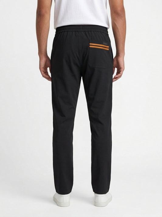 Zegna drawstring tapered trousers in black, model back — The Quiet Edition