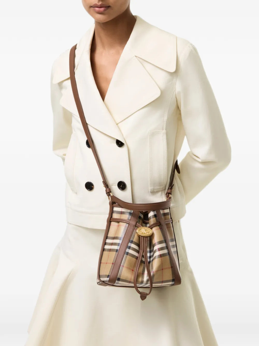 Burberry Mini Check Bucket Bag worn crossbody with a cream jacket and skirt