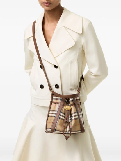 Burberry Mini Check Bucket Bag worn crossbody with a cream jacket and skirt