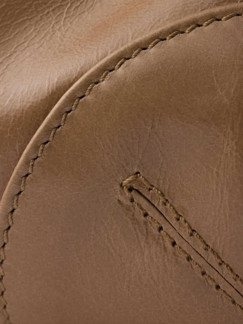 Prada Bonnie handbag detail of glossy tan calf leather with contrast stitching along the base seam