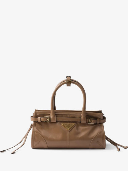 Prada Bonnie mini handbag in tan glossy leather, front view with gold buckles and triangle logo plaque