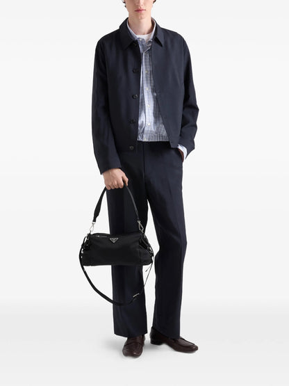 Prada Explore Re-Nylon hobo bag in black, model holding by handle — The Quiet Edition
