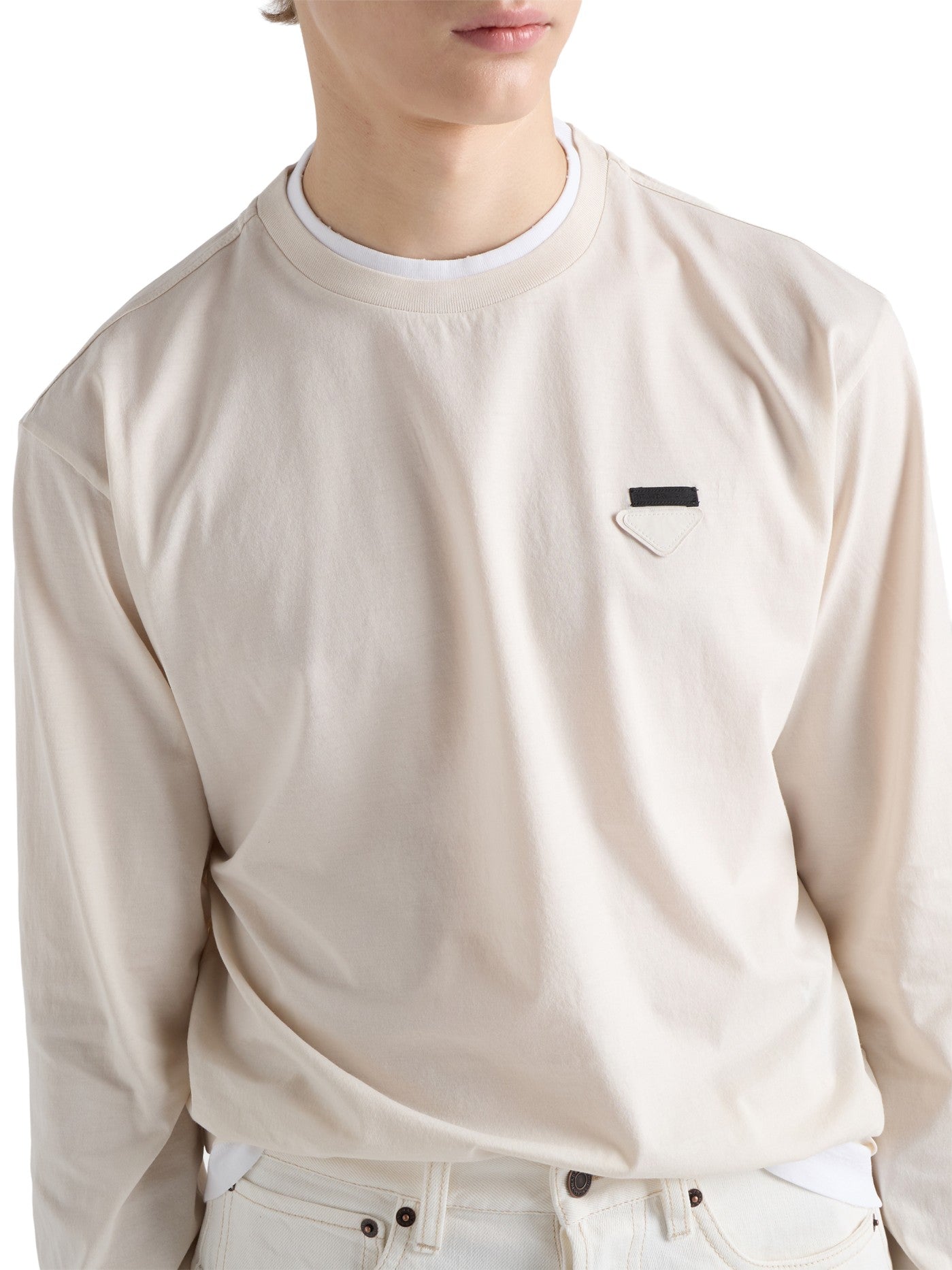 Prada Long-Sleeved Cotton T-Shirt in beige, close-up of triangle logo plaque and white collar trim