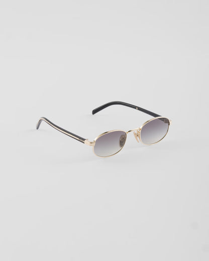 Prada PR B53 oval sunglasses in pale gold, three-quarter angle — The Quiet Edition