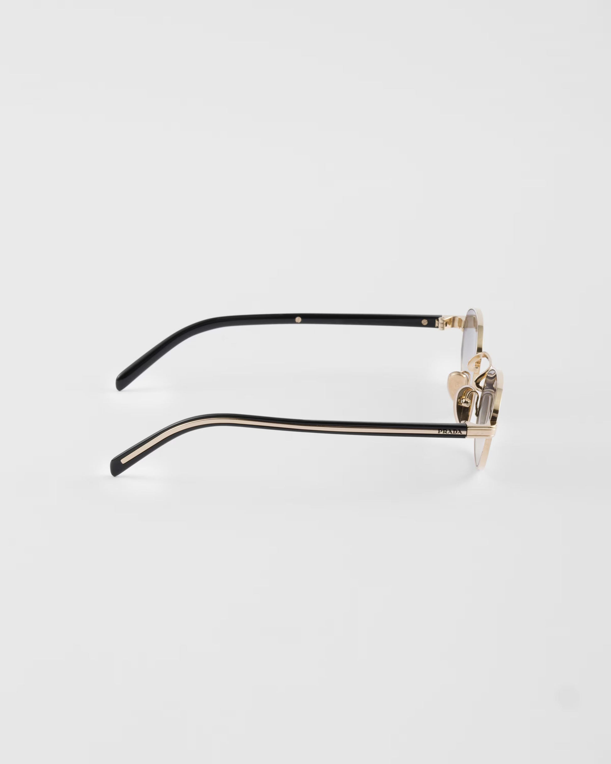 Prada PR B53 oval sunglasses in pale gold, side temple view — The Quiet Edition