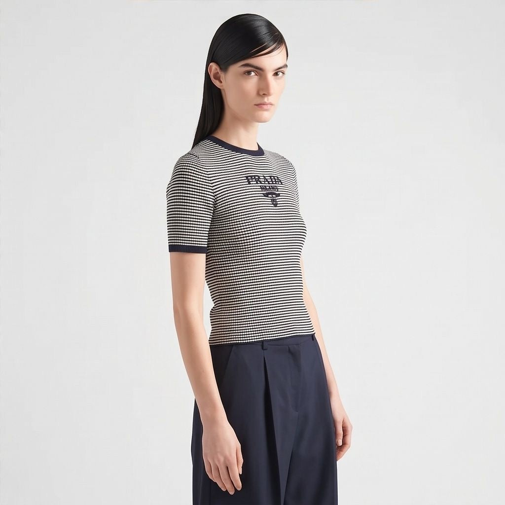 Prada silk cropped logo sweater in navy stripes, model side view — The Quiet Edition