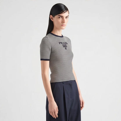 Prada silk cropped logo sweater in navy stripes, model side view — The Quiet Edition