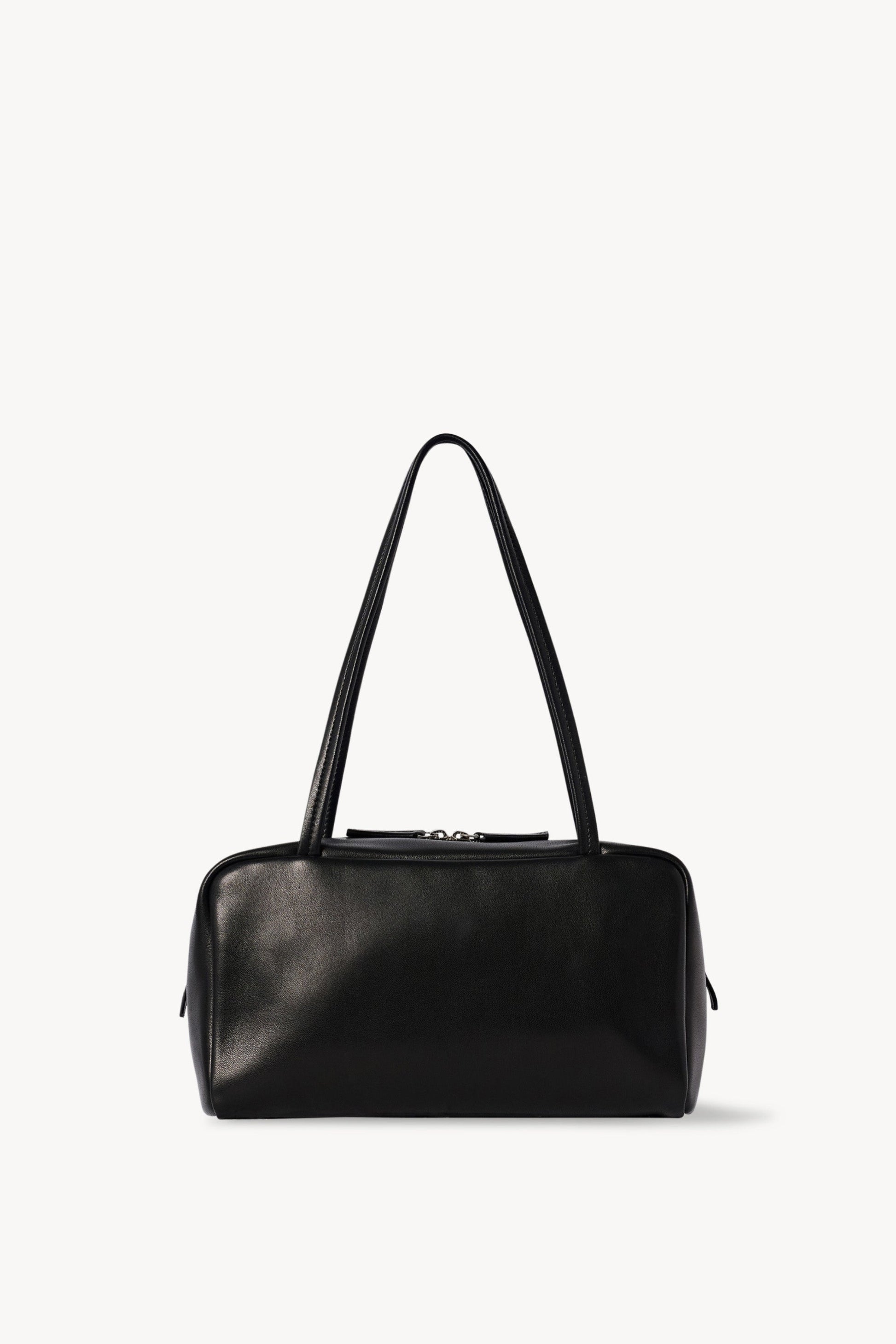The Row Astra Bag in black, front view of the soft nappa lambskin bowling silhouette with flat handles