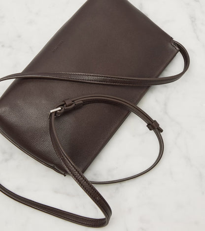 The Row Rene shoulder bag in brown, side view with strap — The Quiet Edition