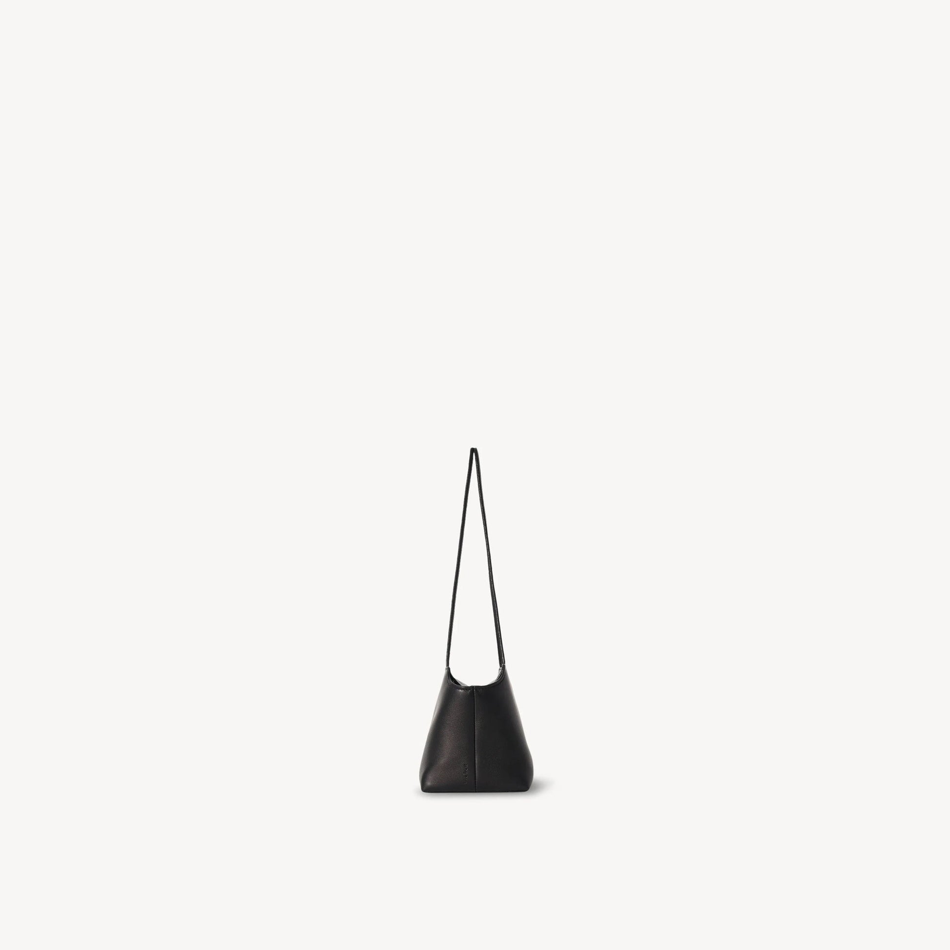 The Row Terrasse leather to-go bag in black, side view — The Quiet Edition