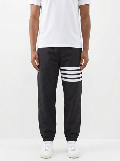 Thom Browne 4-Bar track pants in black, model front — The Quiet Edition