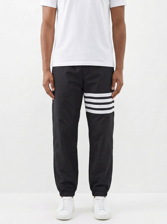 Thom Browne 4-Bar track pants in black, model front — The Quiet Edition