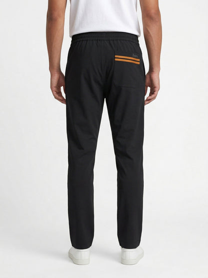 Zegna drawstring tapered trousers in black, model back — The Quiet Edition