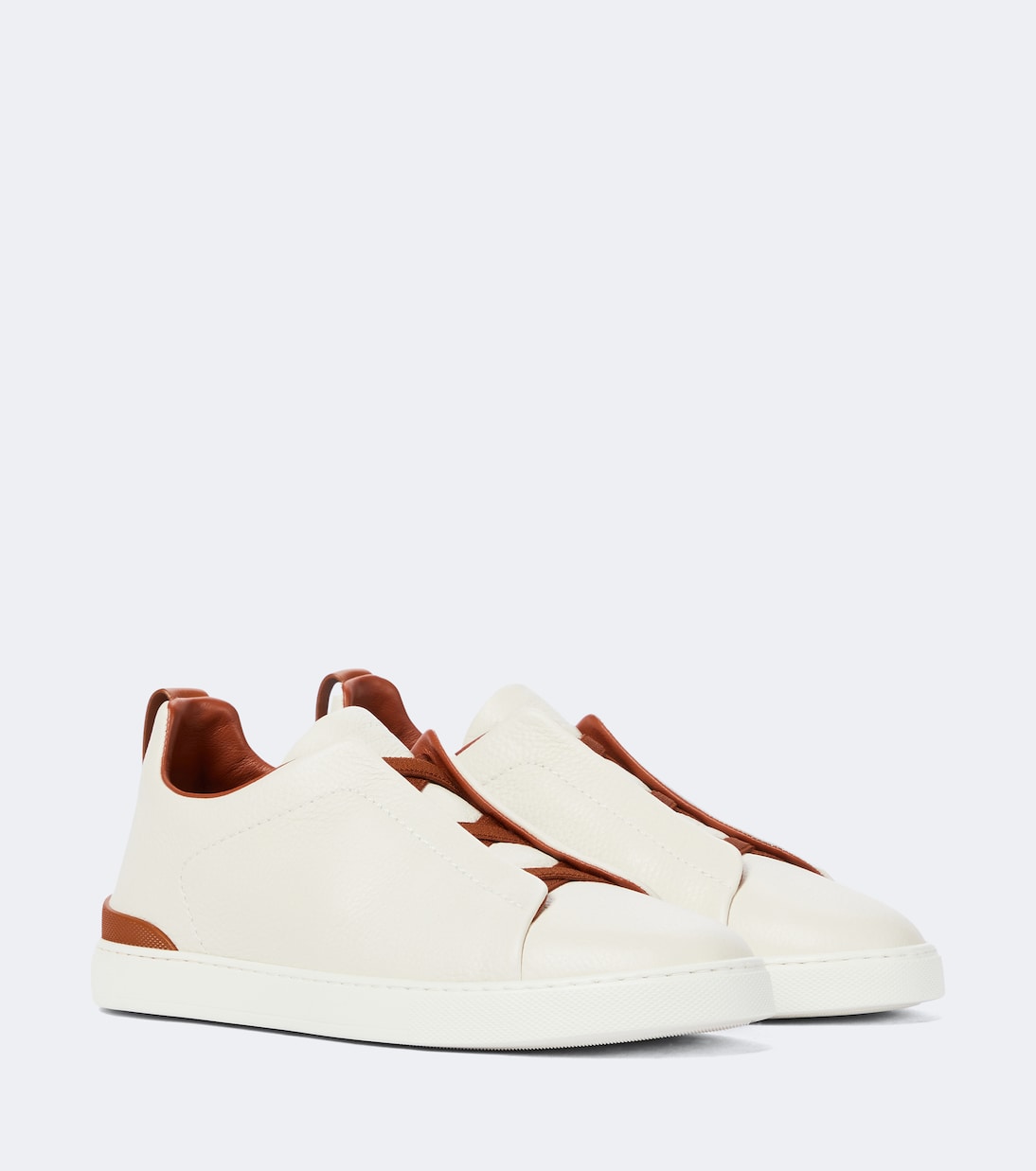 Zegna Triple Stitch leather sneakers in white, angled pair view with brown leather trim